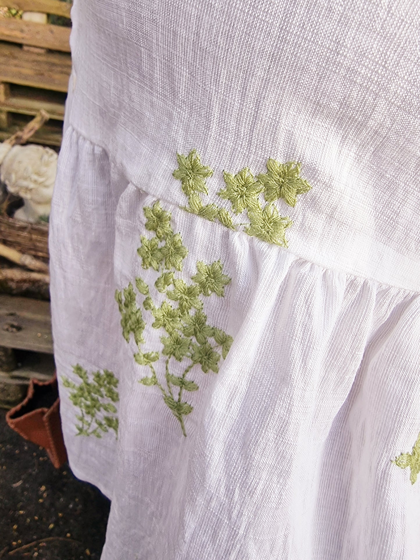 Weisse Bluse mit aufgestickten grünen Blumen und Knopfleiste vorne, romantische Kurzarmbluse mit Rüschensaum