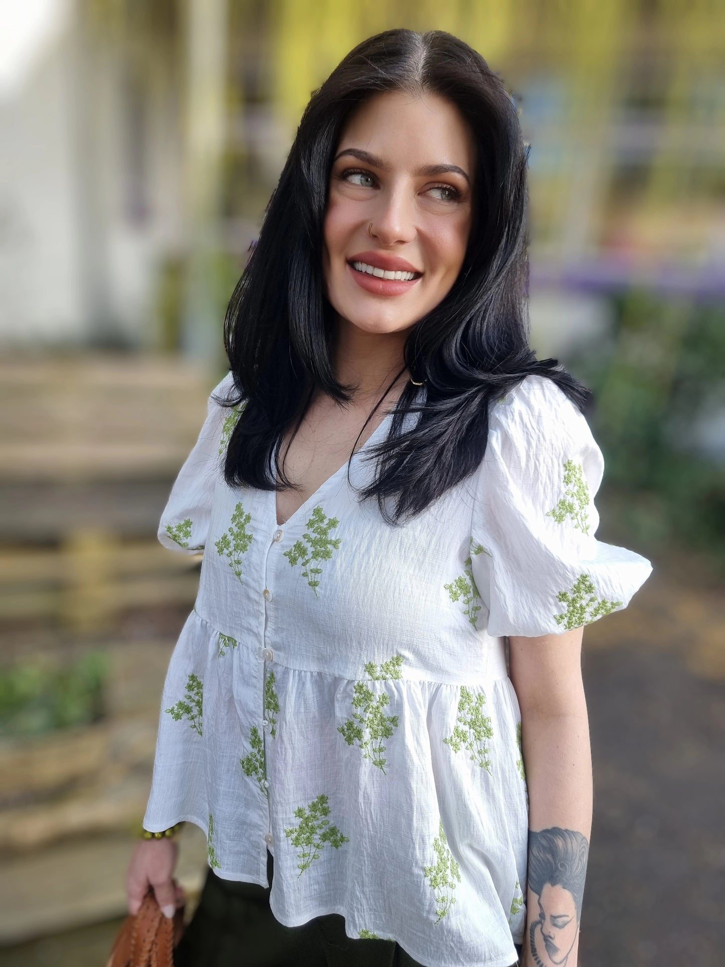 Weisse Bluse mit aufgestickten grünen Blumen und Knopfleiste vorne, romantische Kurzarmbluse mit Rüschensaum