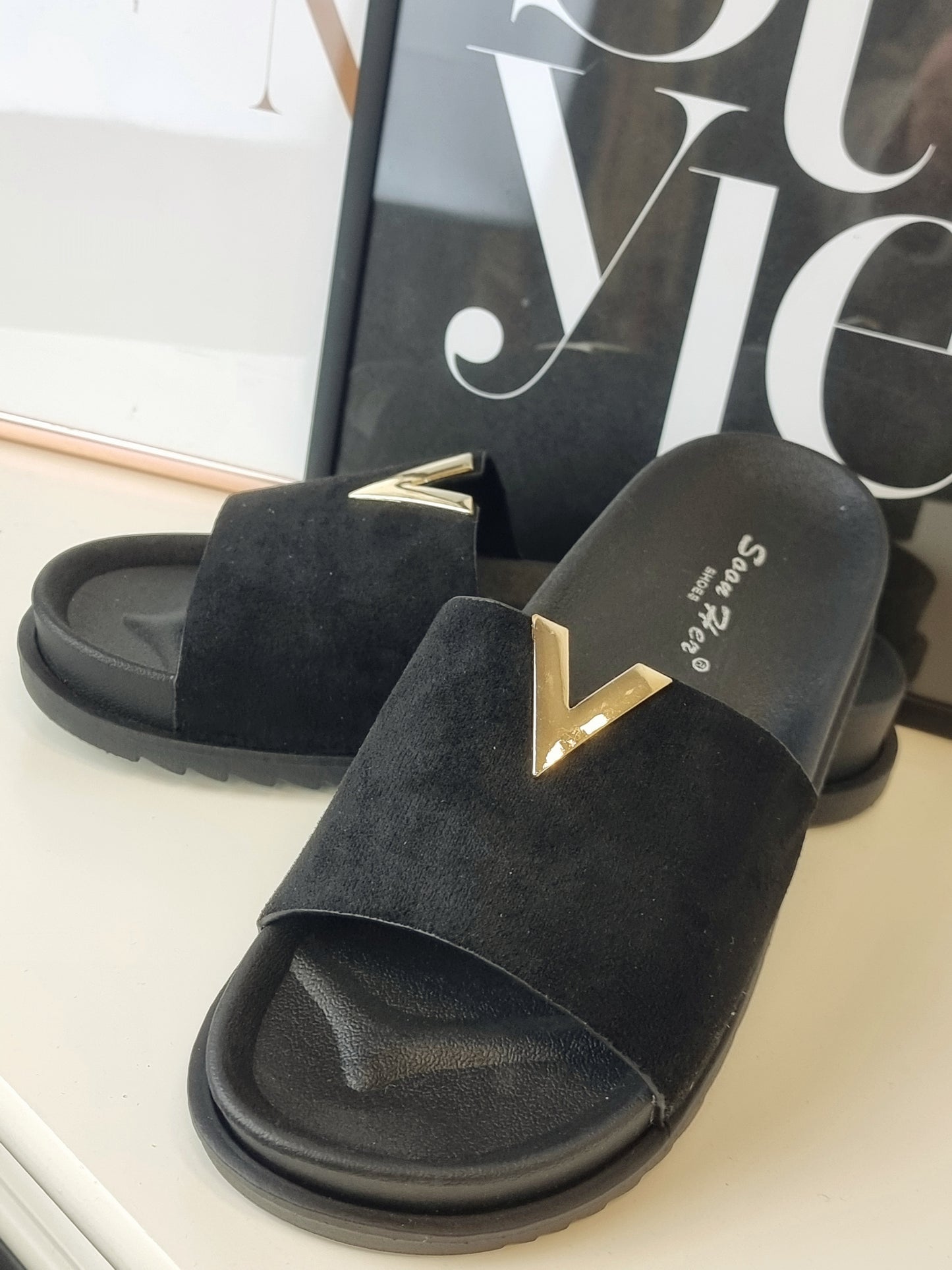 Flache stylische schwarze Sandalen mit Velour Leder und goldenen Details