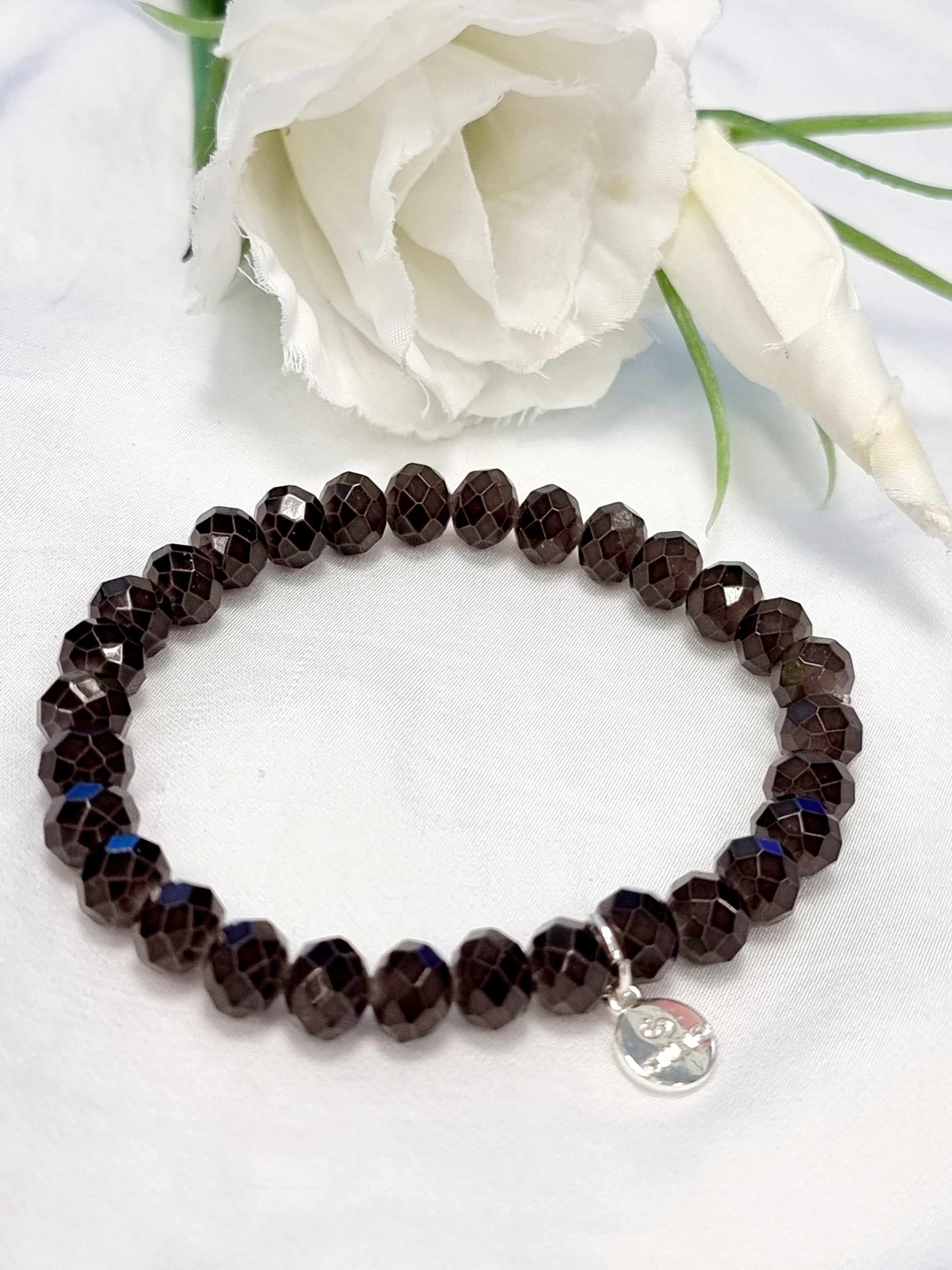 Armband mit dunkelbraunen Kristallperlen und silbernem Anhänger