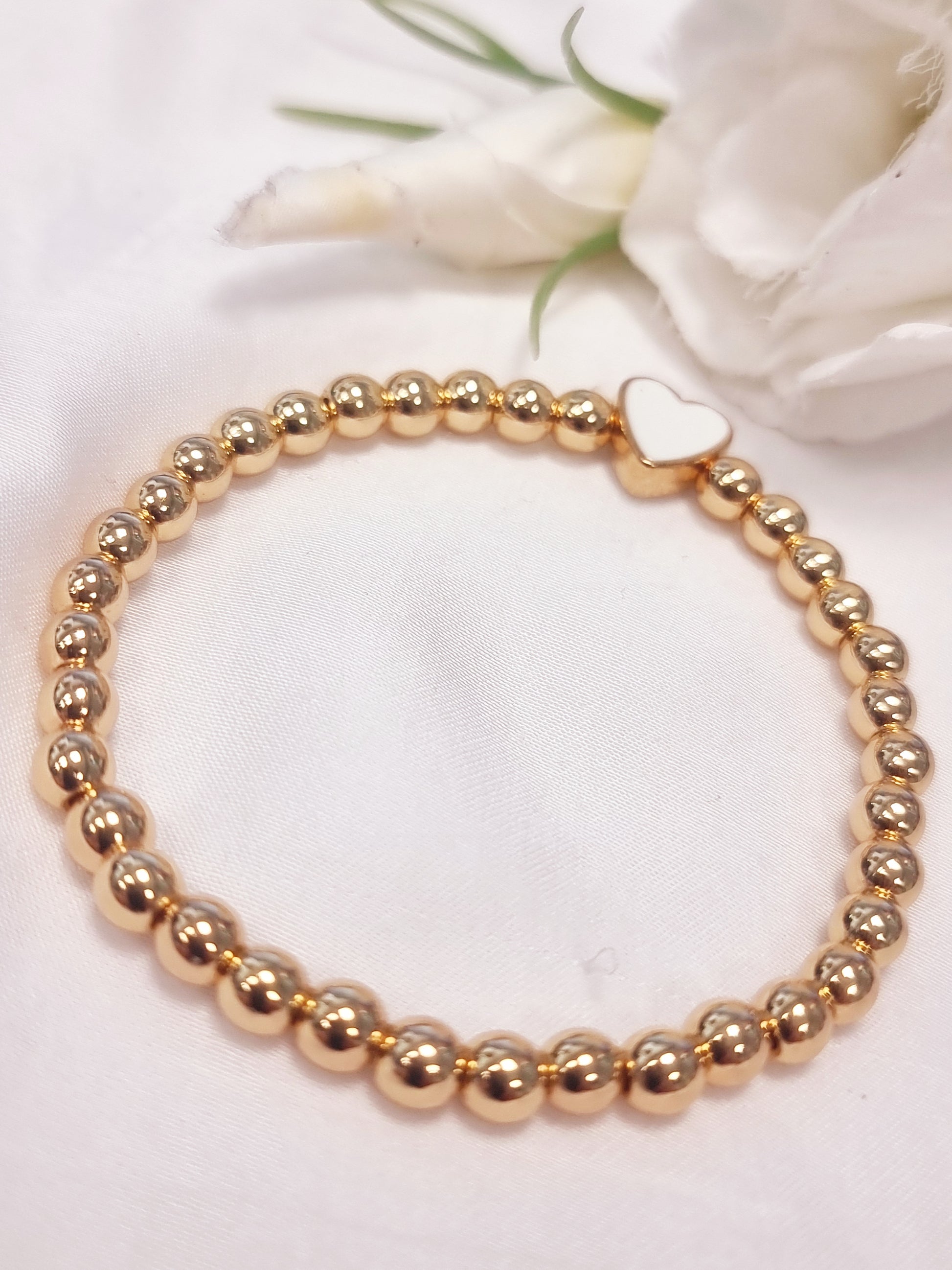 Armband mit goldenen Perlen und emaillierten Herz-Anhänger in Weiß und in Schwarz