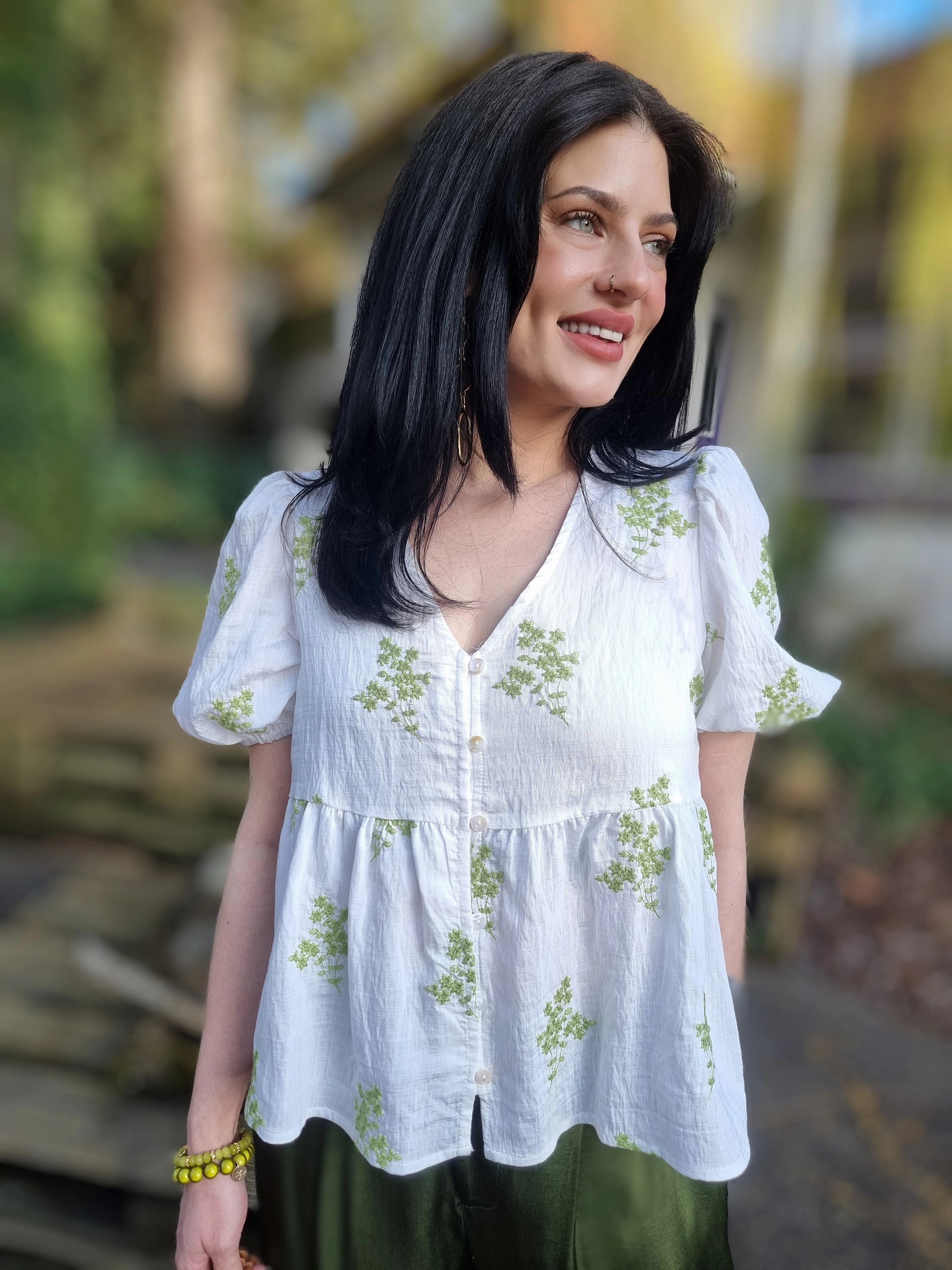 Weisse Bluse mit aufgestickten grünen Blumen und Knopfleiste vorne, Kurzarmbluse mit Rüschensaum